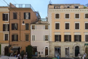 A row of historic buildings with multiple stories, featuring balconies and arched doorways. - Bernini al Borgo - St Peter Vatican (Rome)