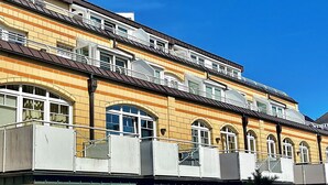 Un edificio a più piani con facciata gialla, diversi balconi e finestre ad arco.