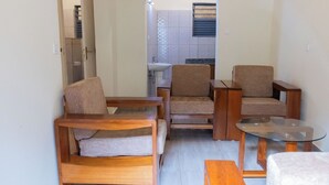 A living room with a sofa, two armchairs, a coffee table, and a bench. - Amakuza Residence (Kigali)