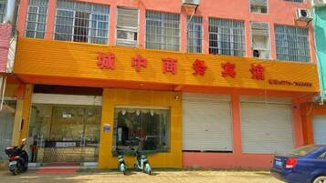 A building with a yellow facade and red signage.