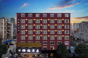 Un hotel de varios pisos con una hilera de ventanas en cada nivel, una entrada visible y un cartel que indica el nombre del hotel.