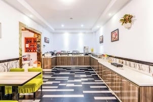 A modern hotel lobby with a bar area, seating, and a patterned floor.