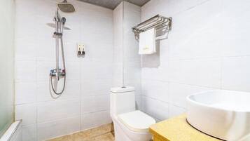 A bathroom with a shower, toilet, and sink.