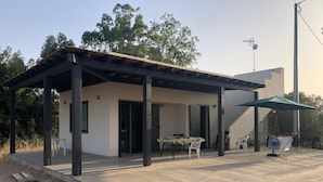 A modern single-story house with a covered patio, a dining table, and a staircase leading to an upper level. - New Panoramic Villino in Porto Palo di Menfi Blue Flag ideal for families  (Menfi)