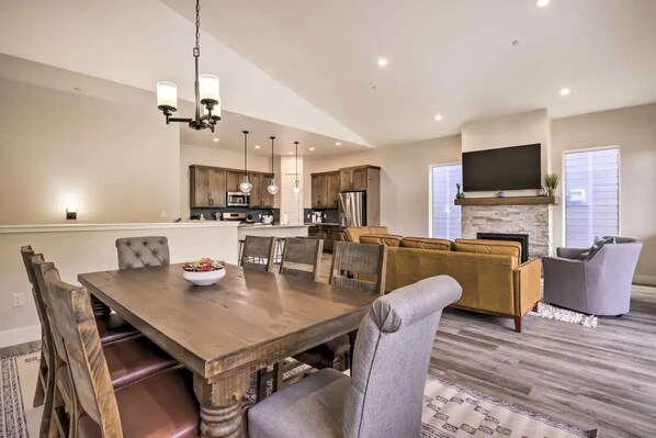 Une cuisine moderne avec des meubles en bois, un îlot central et un coin repas comprenant une table et des chaises en bois.