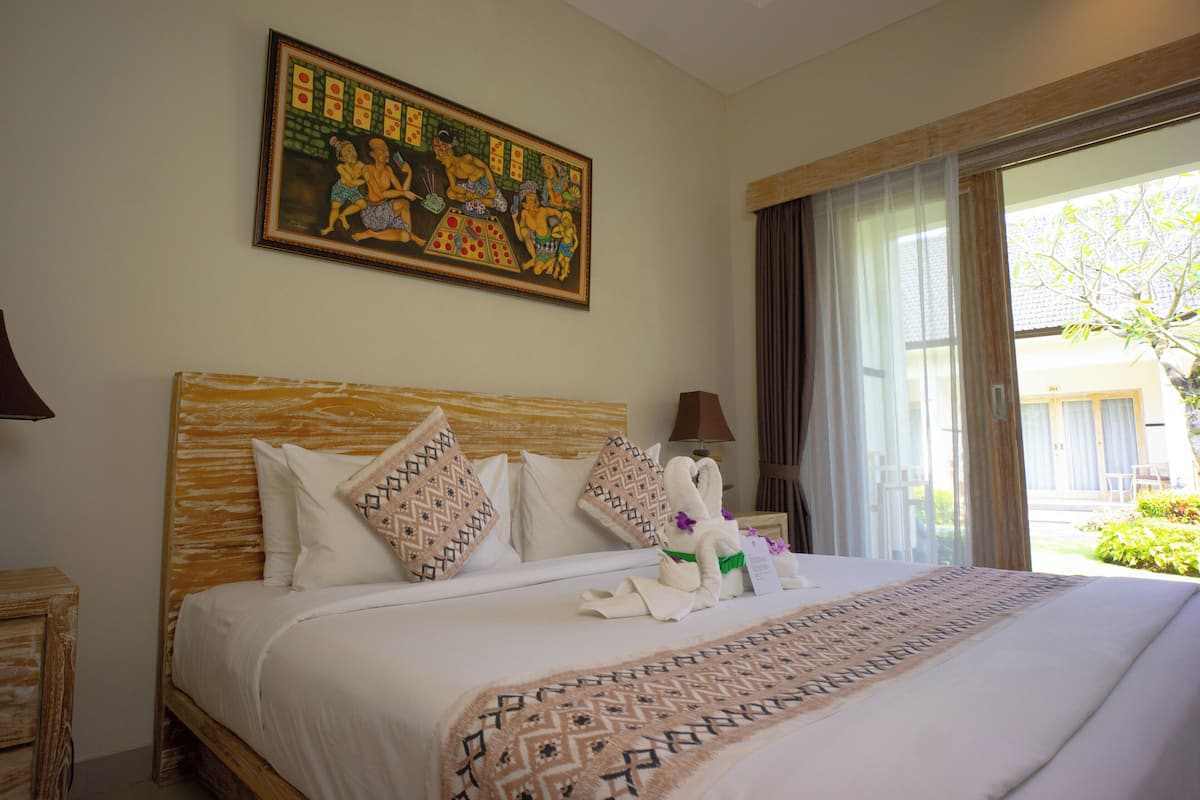 A hotel room with a large bed, a painting on the wall, and a view of the outdoors.