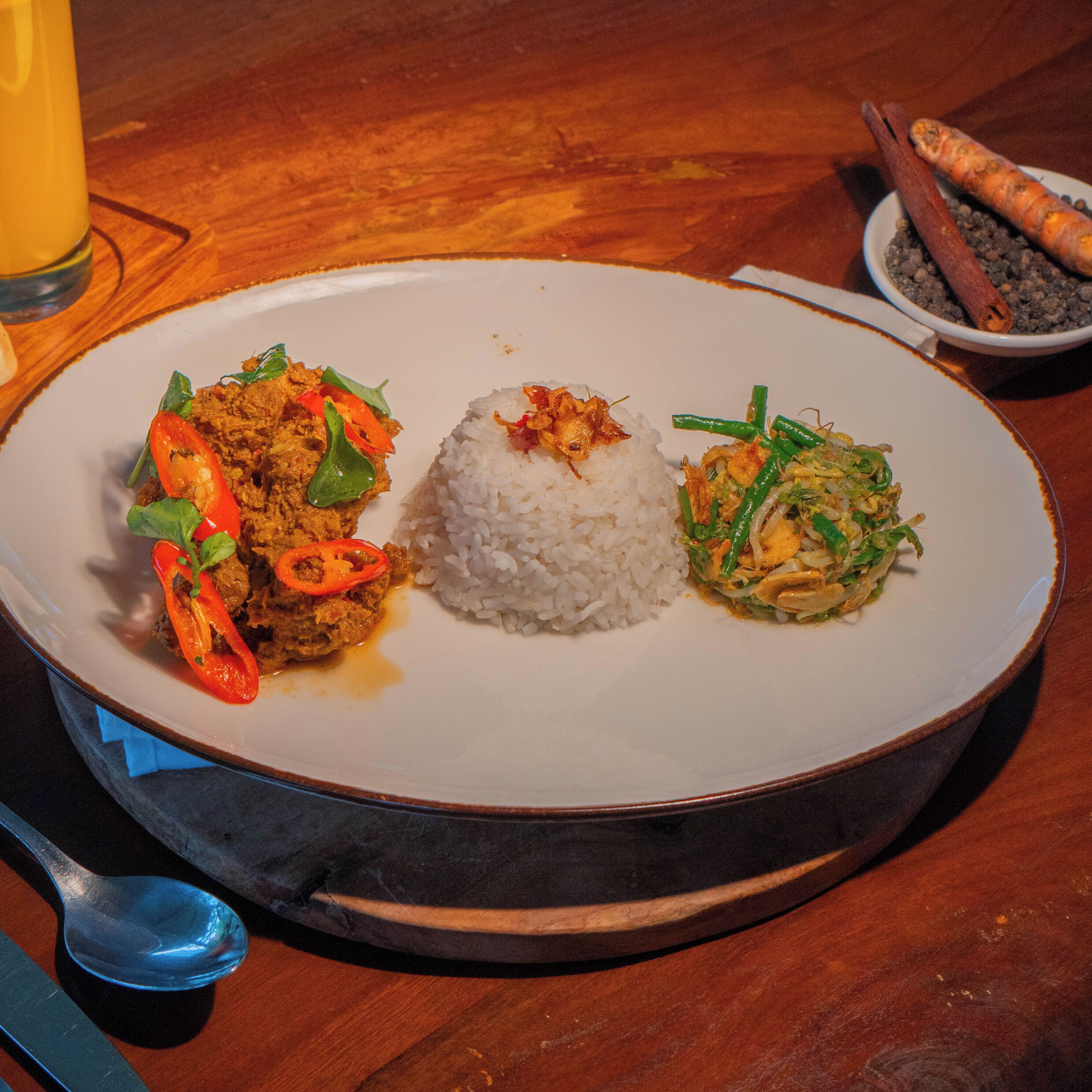 A plate with rice, a meat dish, and a vegetable stir-fry.