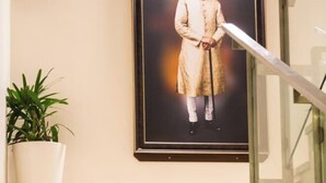 A framed portrait of a person in traditional attire on a wall. - Heritage Inn (Mysore)