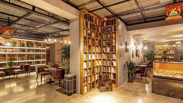 A spacious library with bookshelves, seating areas, and a reception desk.