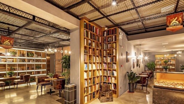 Una biblioteca moderna con estanterías, zonas de estar y un mostrador de recepción.
