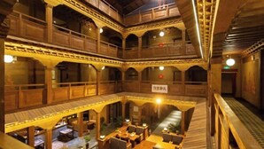 Un interior de madera de varios niveles con balcones y zonas de estar.