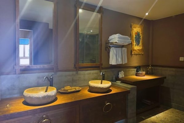 A bathroom with two sinks, a mirror, a towel rack, and a painting on the wall. - Shangri-La Fanyue Mountain Resort (Shangri-La)