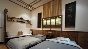 A hotel room with two beds, wooden headboard, wall-mounted shelves, and traditional decor. - Jingxutang Hostel (Wuyuan)