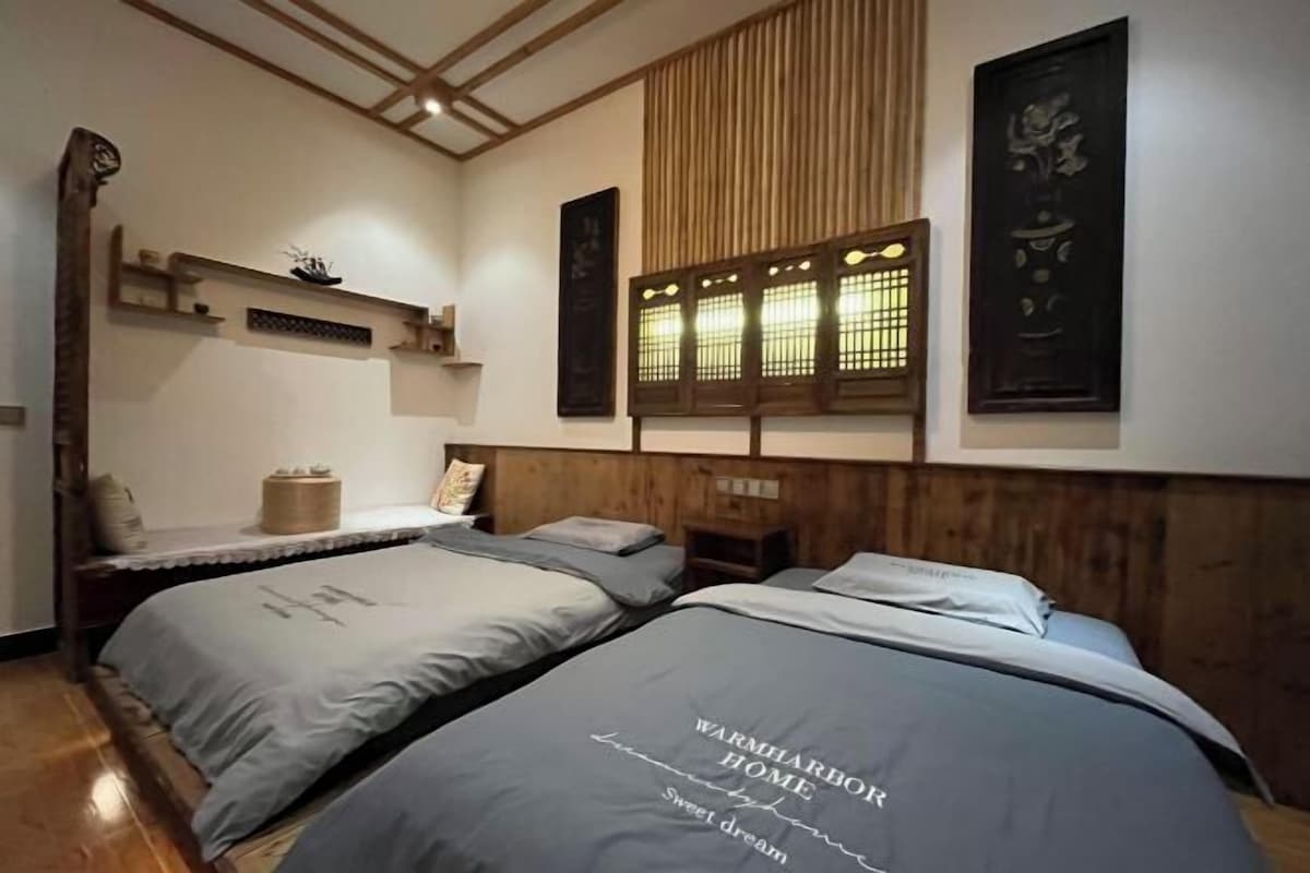 Quarto de hotel com duas camas, cabeceira de madeira, prateleiras na parede e decoração tradicional.