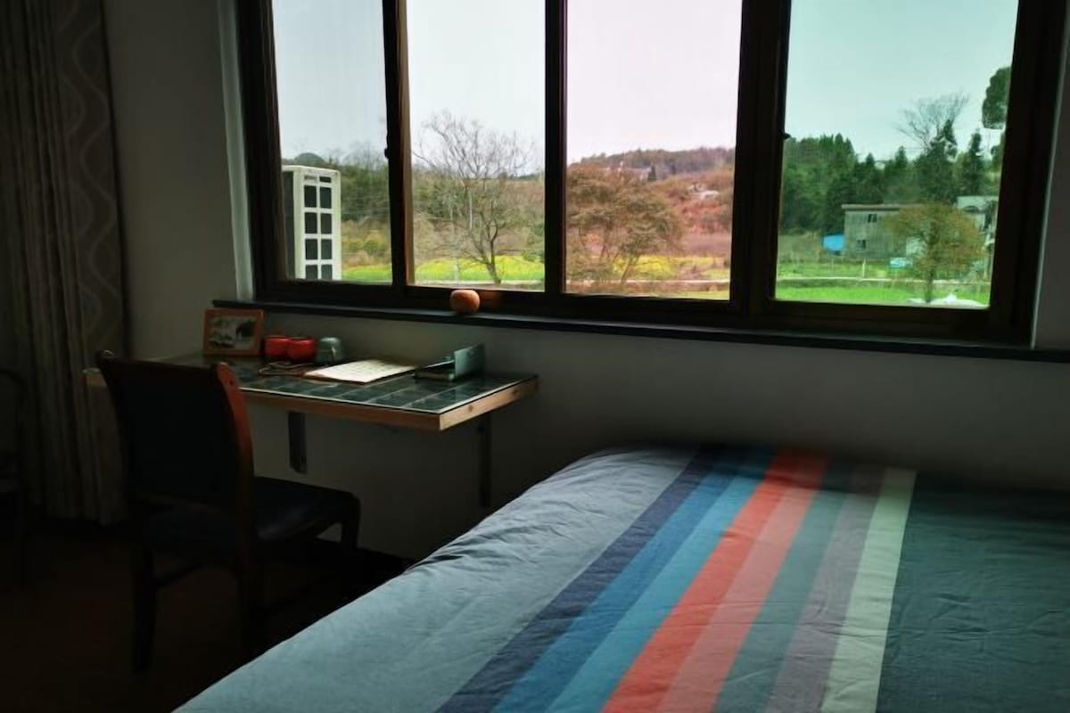 Um quarto com uma cama, uma escrivaninha e uma cadeira.