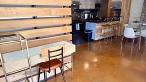 Una cocina moderna con una pared de madera, un comedor con mesa y sillas, y una encimera de cocina.