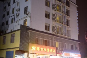 Un edificio de varios pisos con un cartel de hotel en la planta baja.