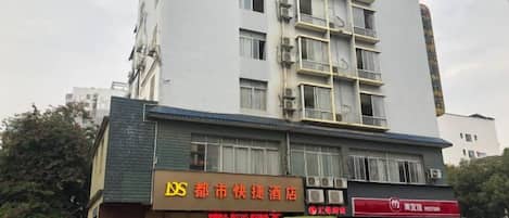 Un edificio de varios pisos con un cartel que anuncia un hotel y un restaurante.
