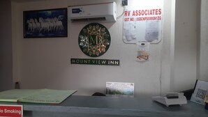 Bancada de recepção no Mount View Inn com uma moldura com cavalos, um emblema decorativo e diversos cartazes informativos.