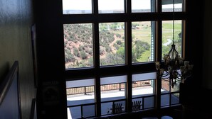 A room with a large window overlooking a landscape, a chandelier, and a seating area with a view. - New Listing!! Luxury cliff-side retreat. Isolated & Serene with EPIC views. (Show Low)