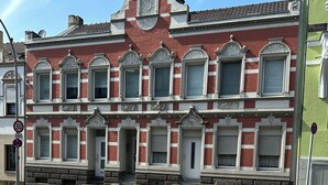 A historic building with a symmetrical facade, large windows, and a central entrance.
