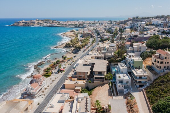 A coastal town with a mix of modern and traditional buildings, a prominent church, and a clear view of the sea.