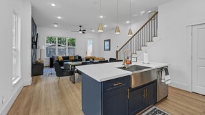 Una cocina moderna con una isla central, electrodomésticos de acero inoxidable e iluminación colgante.