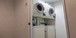 A laundry room with two stacked washing machines and a control panel. - HOTEL SEN (Matsue)