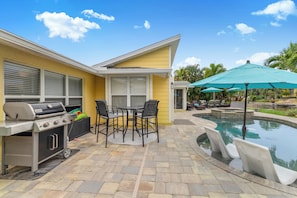 A patio area with a grill, outdoor seating, and a swimming pool. - Luxe 3BR Siesta Key Home Pool (Siesta Key)