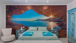 A bedroom with a large bed, a white armchair, and a nightstand with a lamp. - Villa LunaMoon (Playa Blanca)