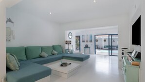 A modern living room with a sectional sofa, a coffee table, and a flat-screen TV. - Villa LunaMoon (Playa Blanca)