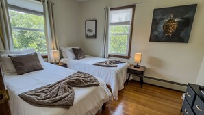 A hotel room with two beds, a nightstand with a lamp, a framed picture, and a large turtle painting on the wall. - Elegant 4BR Princeton Escape • Game Rm • Big Yard (Princeton)