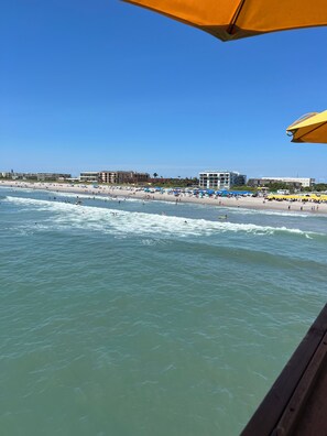 A beach with umbrellas and people.