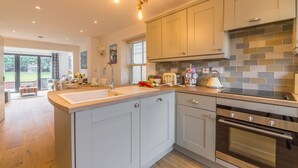 A modern kitchen with a central island, stainless steel appliances, and a view to the outside.