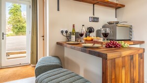 Una cucina con un piano di lavoro in legno, un tostapane e una ciotola di uva.