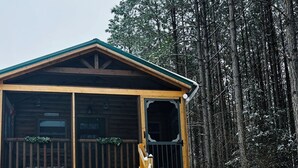 A wooden cabin with a covered porch and a staircase leading up to it. - Falcons Nest cabin with AC and WiFi in enchanting Calhoun TN (Calhoun)