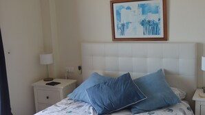 A bedroom with a bed, a nightstand, a lamp, a ceiling fan, and a framed picture on the wall. - Penthouse with exceptional views (La Manga)