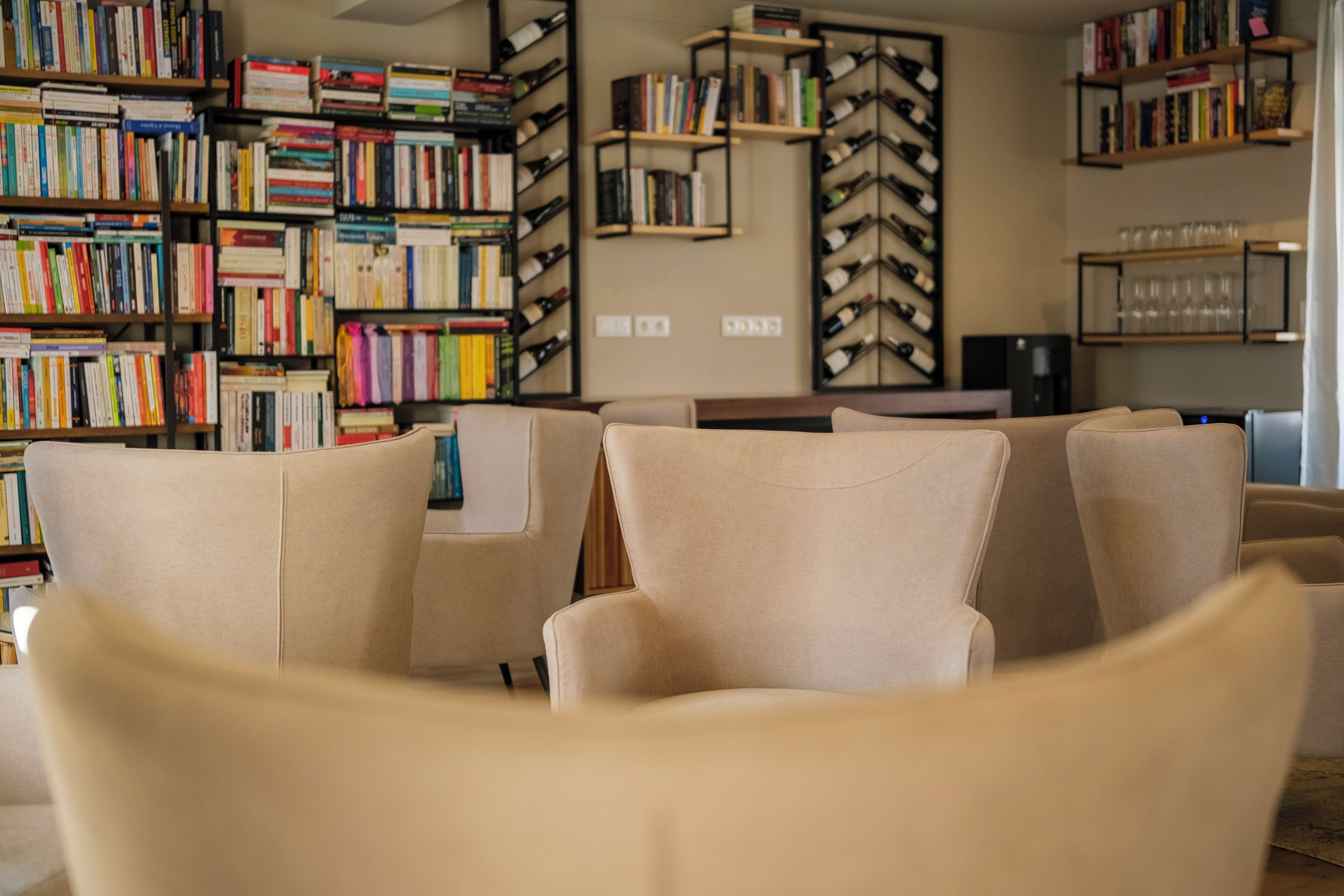 Una biblioteca con numerosas estanterías llenas de libros y una zona de estar con sillas.