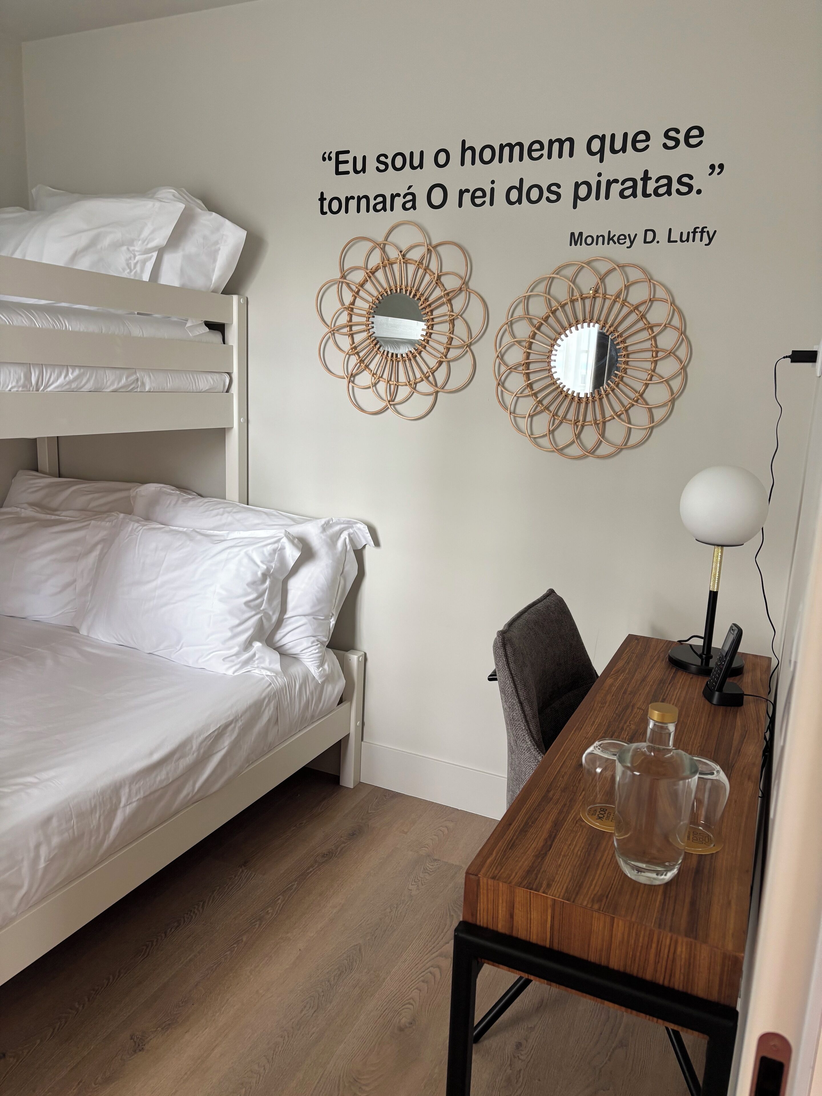 Una camera da letto con un letto a castello, una scrivania con una lampada e decorazioni murali.