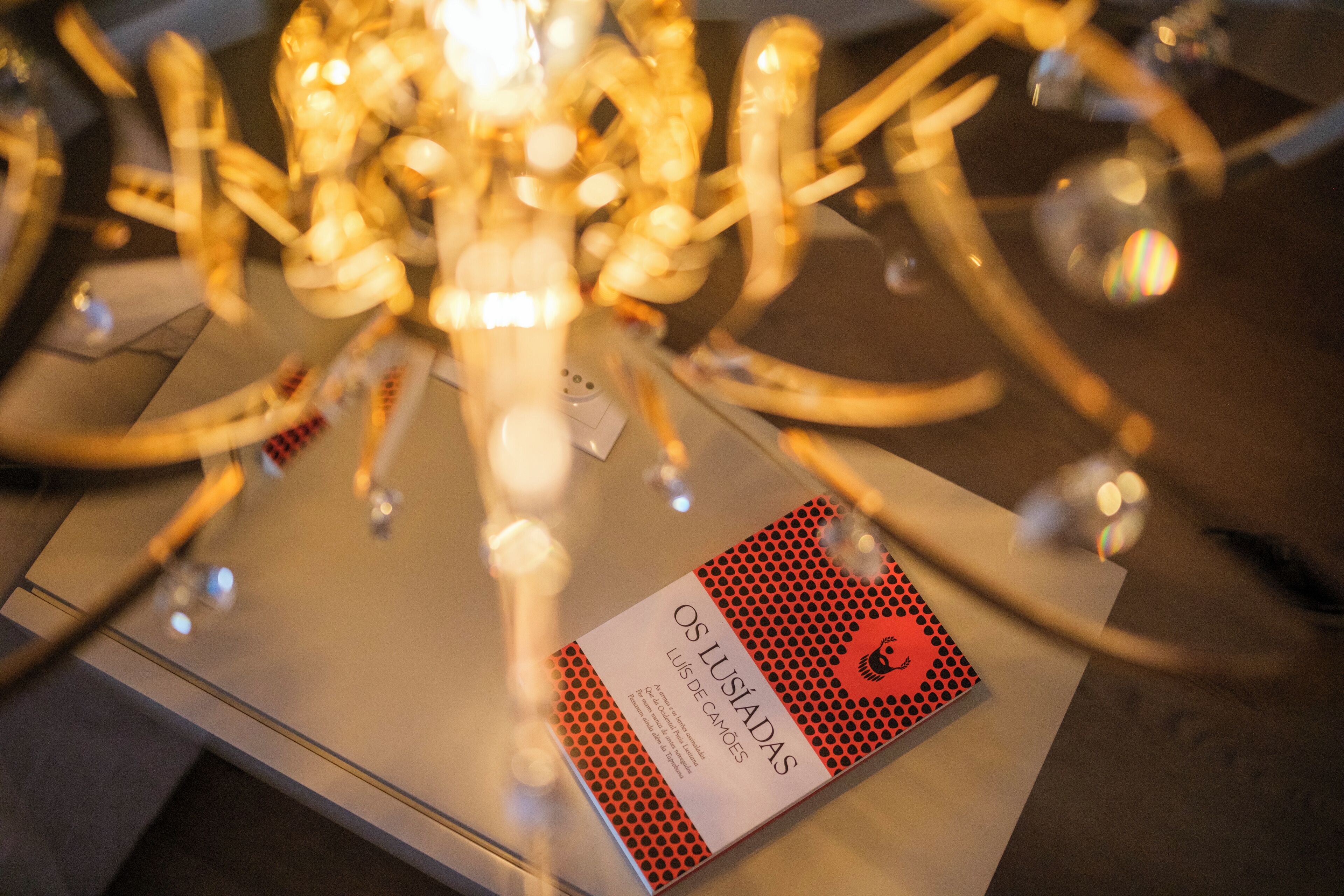 A chandelier with multiple light fixtures and a plaque with text.