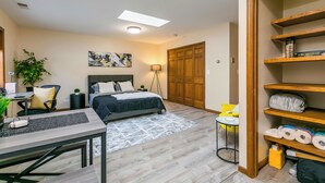 Une chambre à coucher avec un lit, un bureau, une chaise et des étagères.