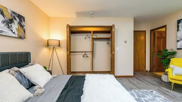 A bedroom with a bed, a wardrobe, a lamp, and a chair.