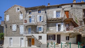 A multi-story stone building with balconies, white shutters, and a staircase leading to the upper floors. - 2 bedroom beautiful home in Sollacaro (Sollacaro)