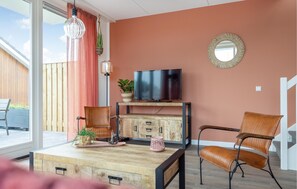 Relax in this stylish living room with a flat-screen TV, comfortable seating, and a large window offering a view of the surrounding deck.