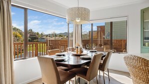 Comedor con una mesa dispuesta para cuatro, ventanas amplias y vistas al exterior.