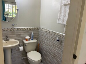 Ein Badezimmer mit Toilette, Waschbecken und Spiegel.
