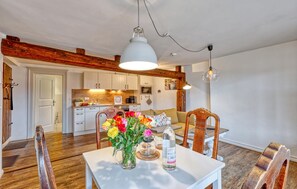 Relax in this open-plan living space with a dining area, featuring a sofa, coffee table, and a dining table with chairs.