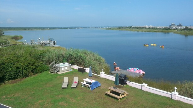 A lakeside property with a hot tub, lounge chairs, a barbecue, and kayaks on the water. - Sea Shell Motel (Westerly)