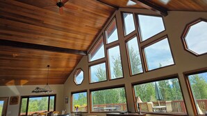 A spacious room with large windows, a ceiling fan, and a wooden ceiling. - Spacious Lodge in Charming Palmer with Incredible Mountain Views (Palmer)