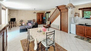 A spacious living area with a dining table, chairs, a sofa, and a staircase leading to another level. - Lovely home in Paulin with kitchen (Paulin)